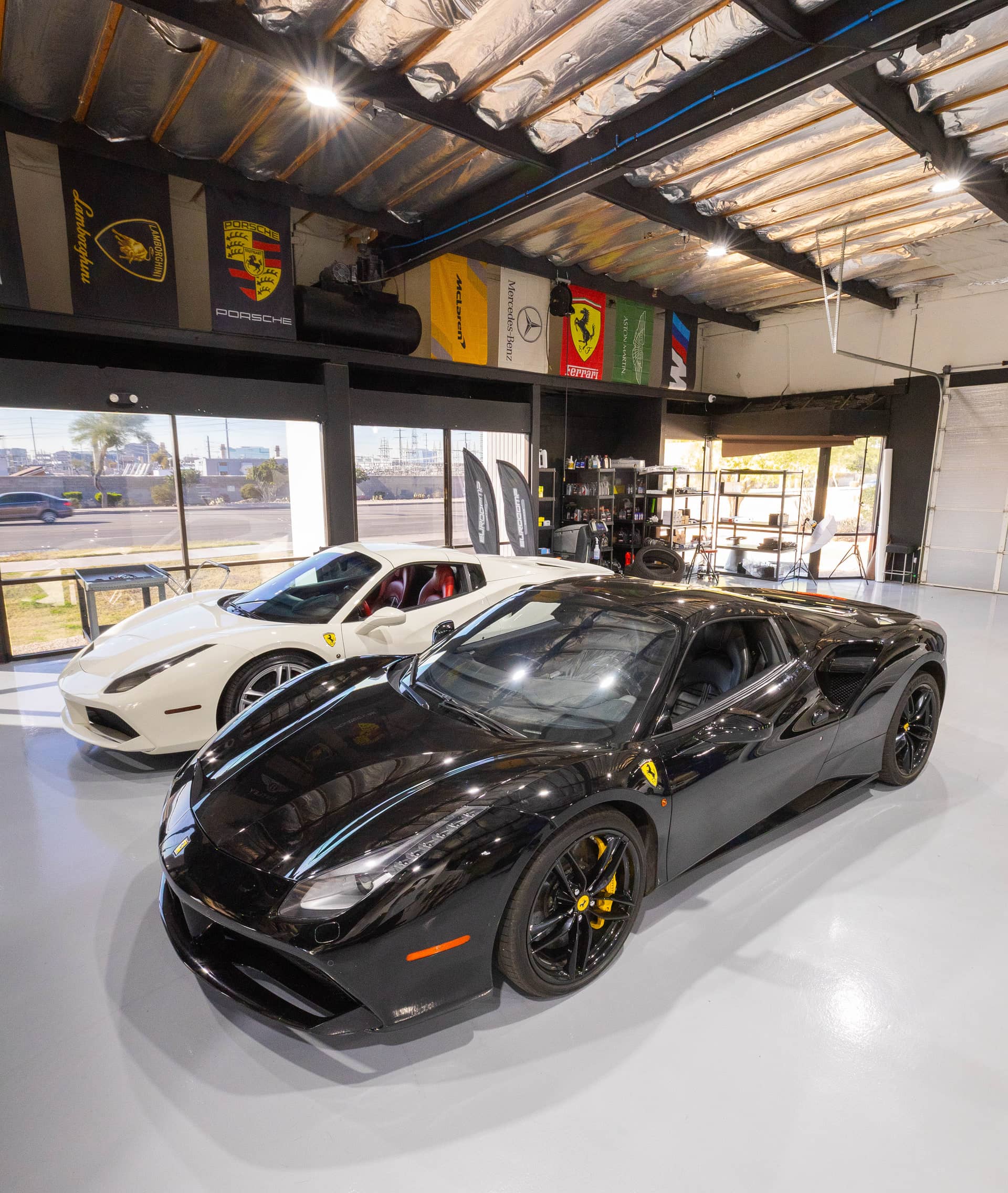 Black and white Ferrari 488s parked inside the EuroComp Garage workshop